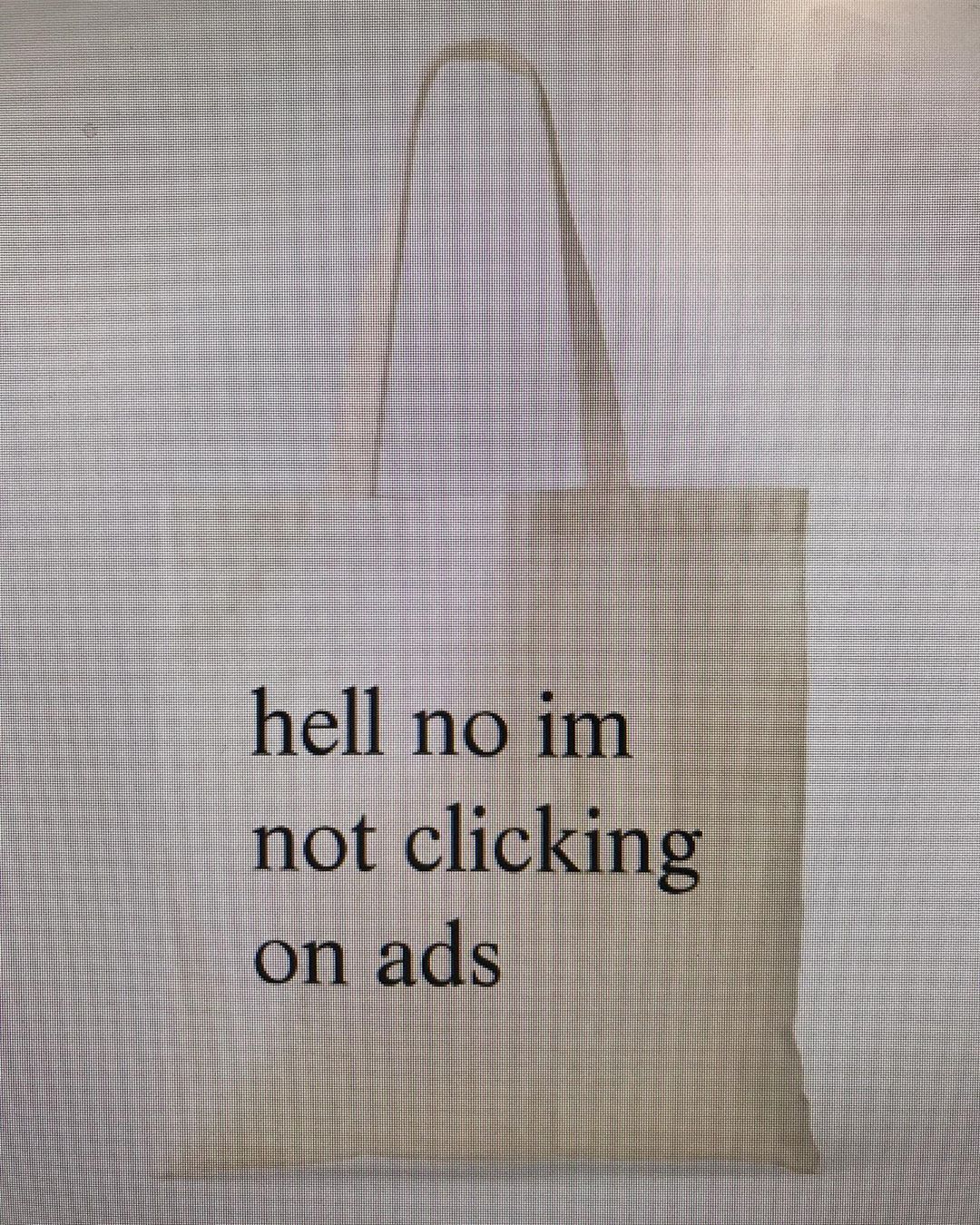 close up photograph of a computer screen, cropped to only show a catalog product image of tote bag with 'hell no im not clicking on ads' printed in large times new roman font
